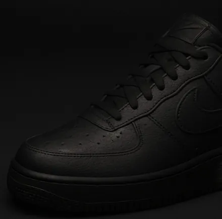 Before: black sneakers in a dark, flat photo