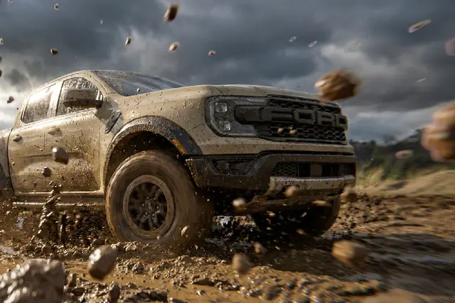 Concept: a Ford Ranger pickup tearing through mud, with clods of earth flying around it