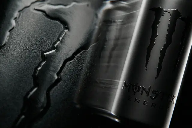 Concept: a matte black Monster Energy can in a dark, dusty scene