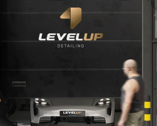 New LevelUP detailing logo on the studio gate, with a car and a passerby in front